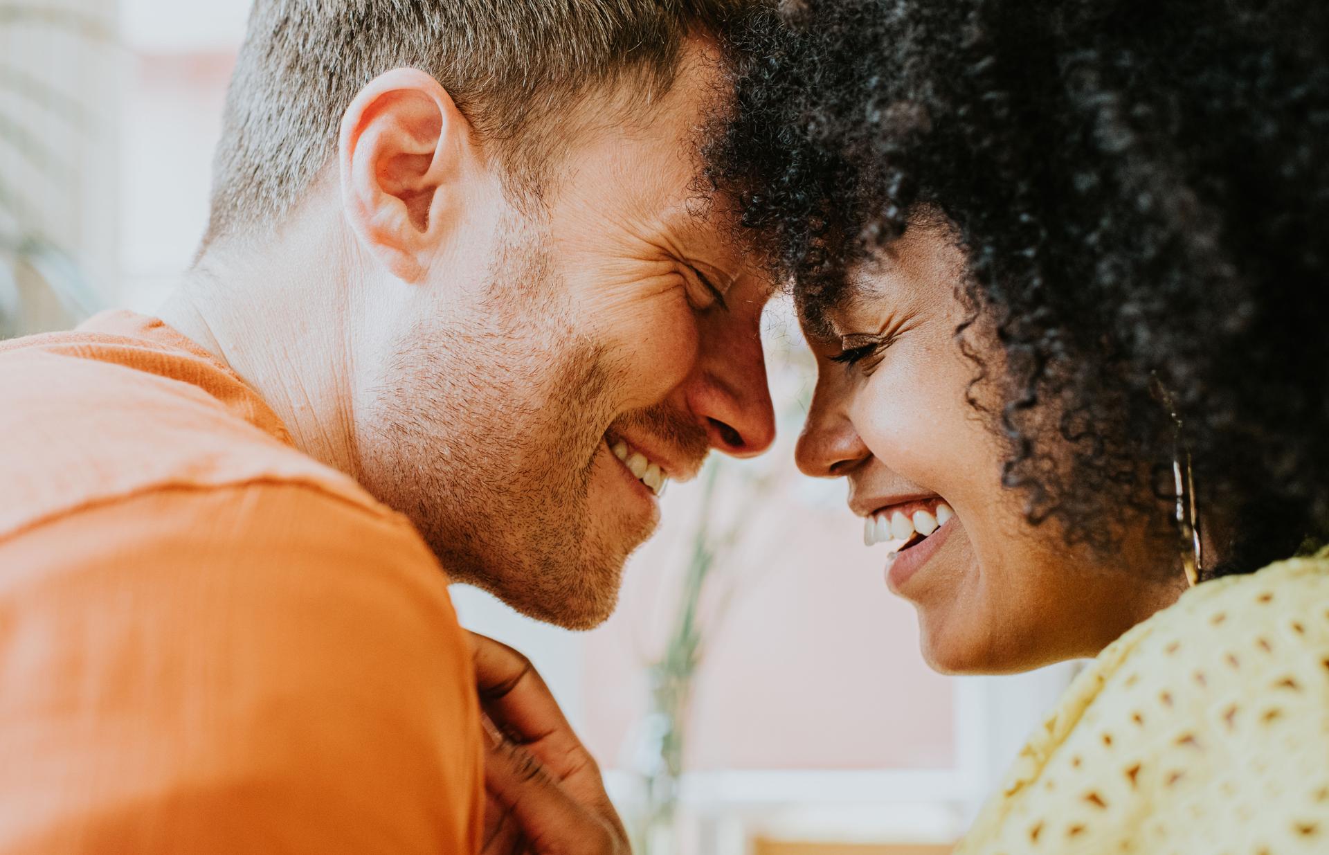 a couple smiling while having open and honest communication about their sex life, improving their relationship dynamic by understanding the connection between menopause and sex drive 