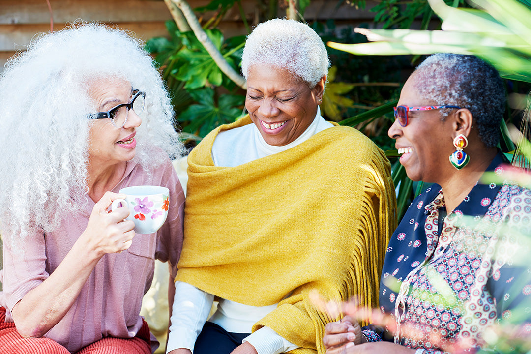 three people smiling while chatting about how to survive hot flashes during menopause