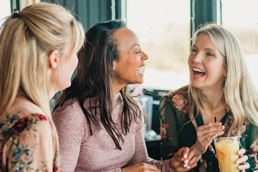 three friends going through menopause enjoying food together and sharing their menopause stories