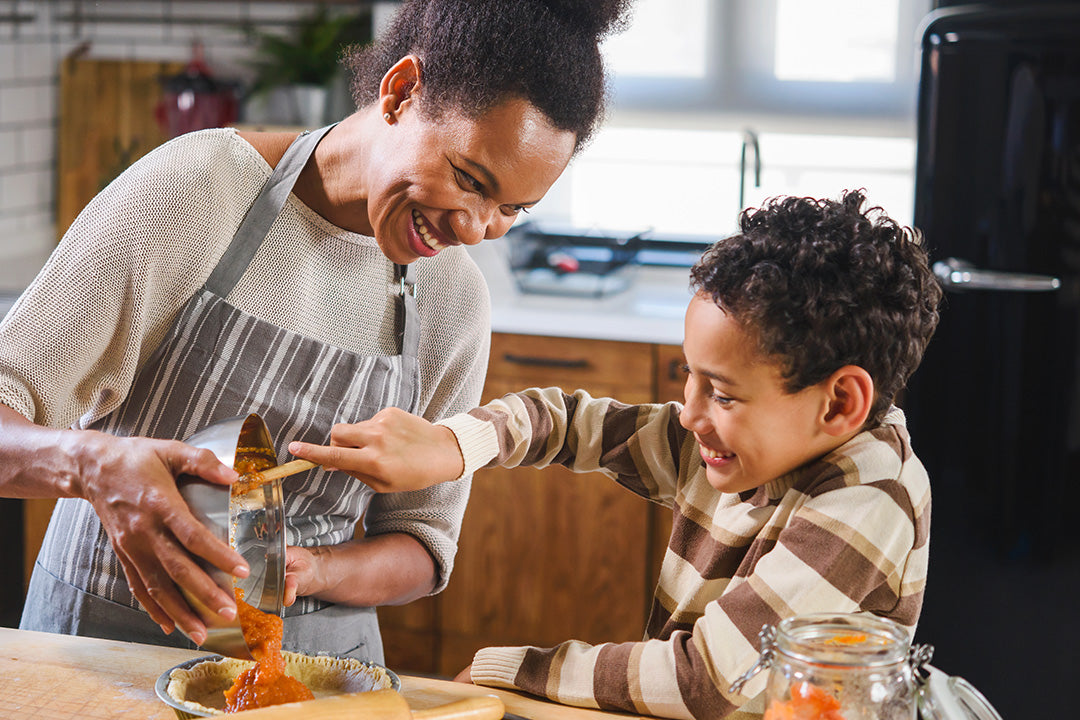 Woman going through perimenopause prepares healthy fall foods with her son