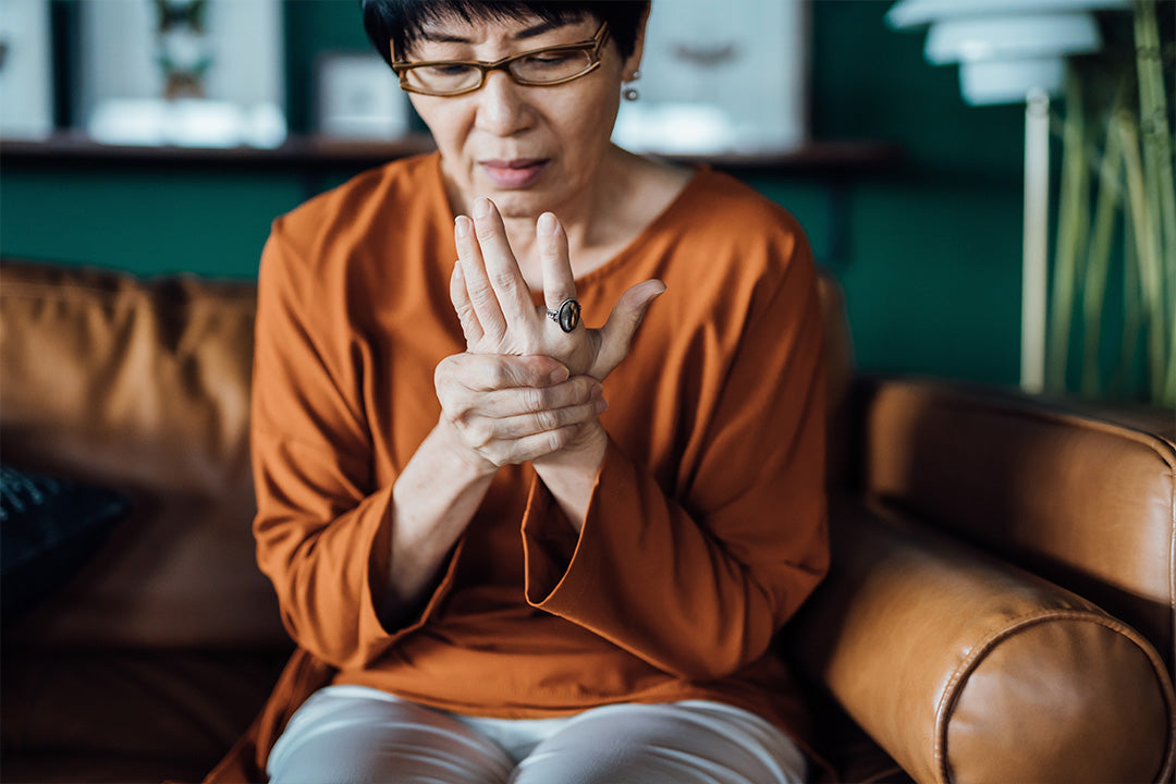 woman experiencing joint stiffness in her hand and finding options to relieve menopause joint pain