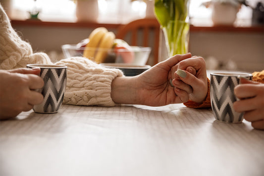 two people holding hands, enjoying coffee, & having a providing comfort about a hysterectomy and surgical menopause