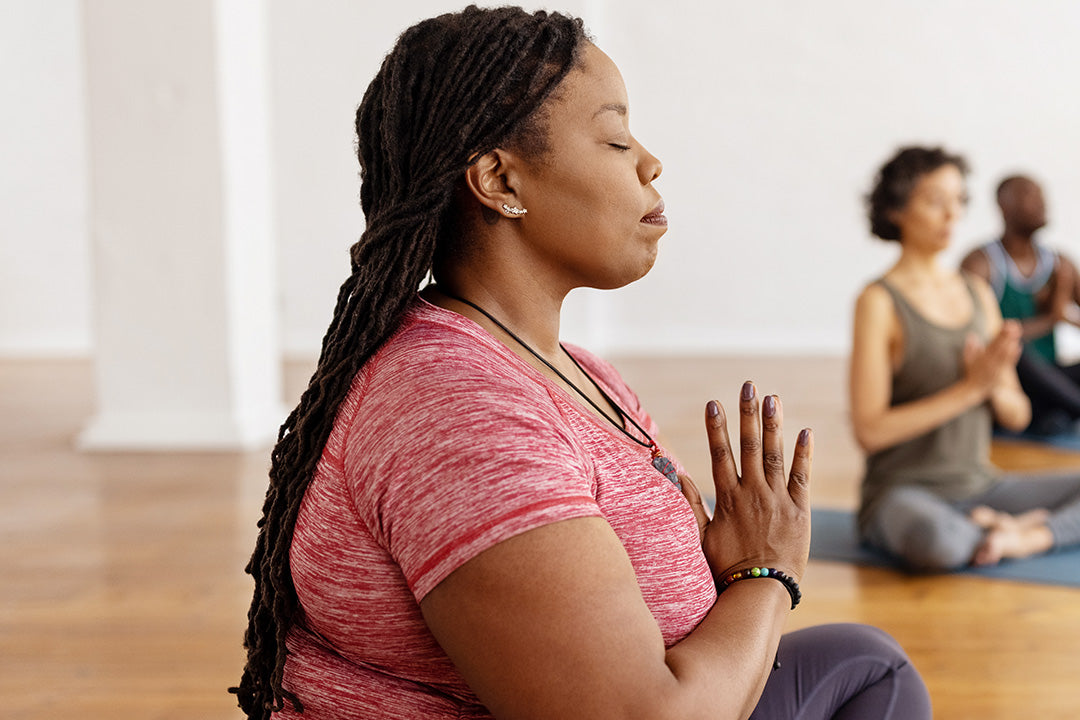 woman in perimenopause relaxing and being mindful in a yoga class