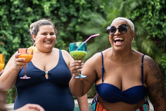 two women in bathing suits raising a glass to drinking moderate amounts of alcohol during menopause 