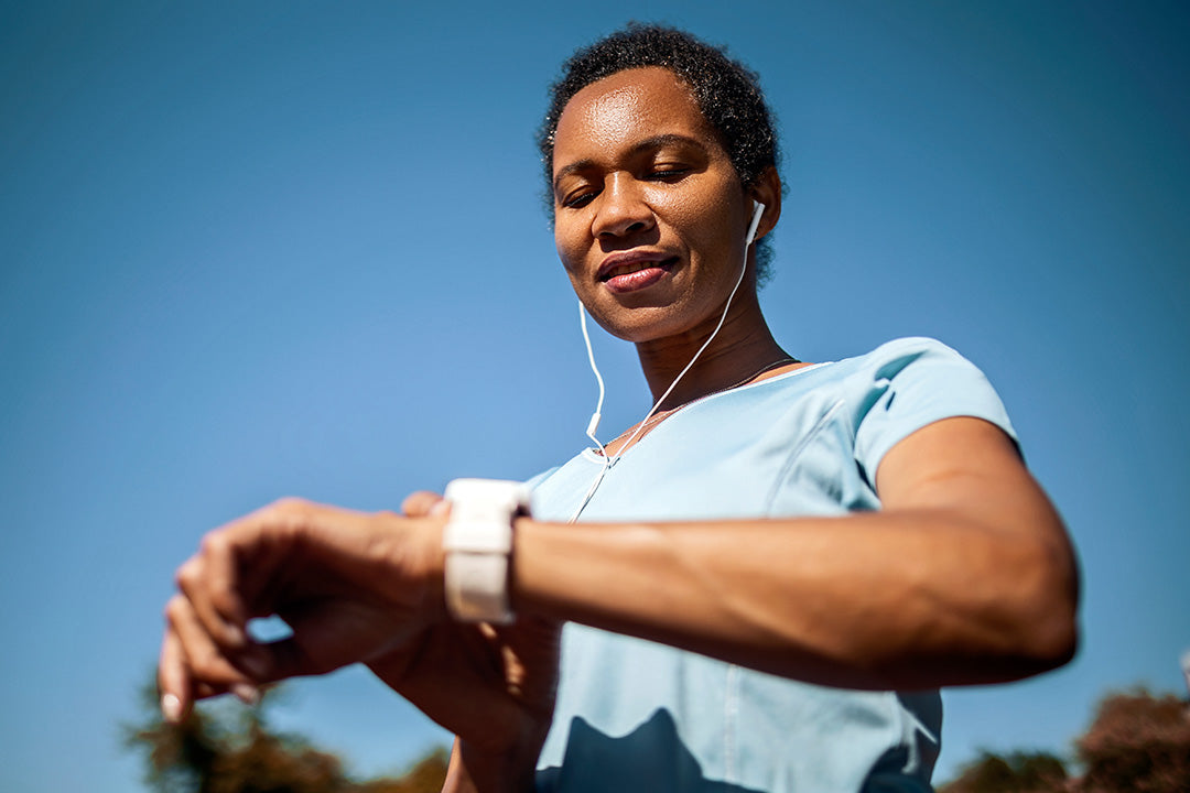 woman looking at her watch as she prepares to go on a run to maintain a healthy weight during menopause