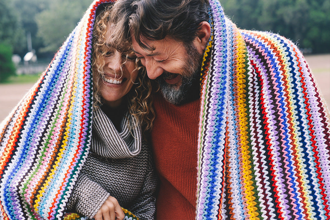 smiling couple wrapped in a blanket discussing menopause tips for husbands