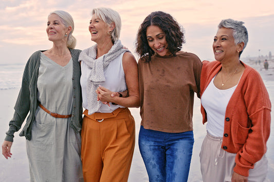 four people talking about what is menopause while walking on a beach