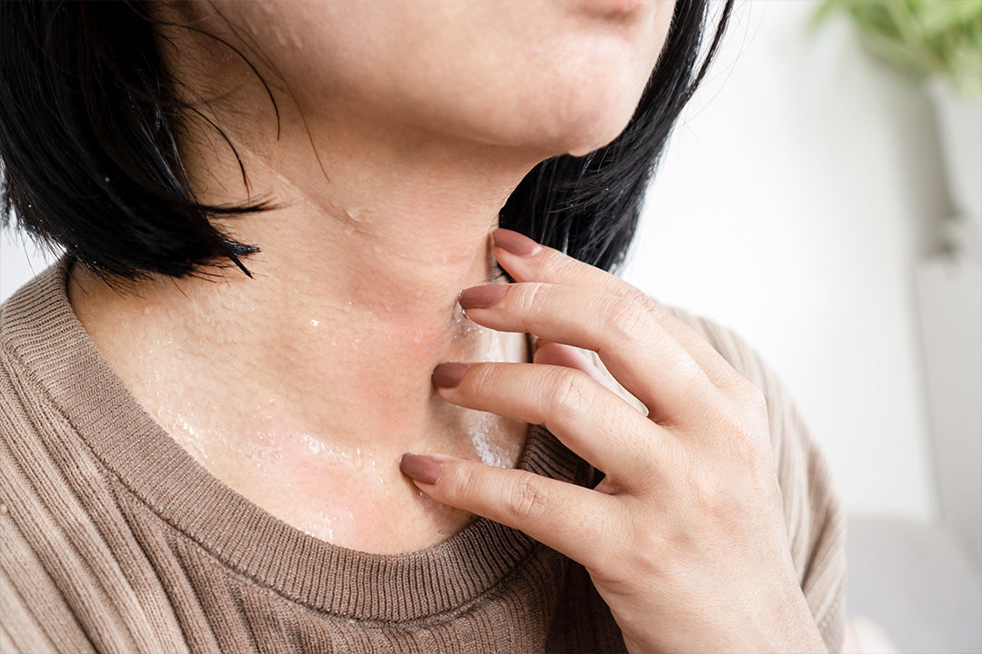 woman sweating as she experiences a hot flash during menopause