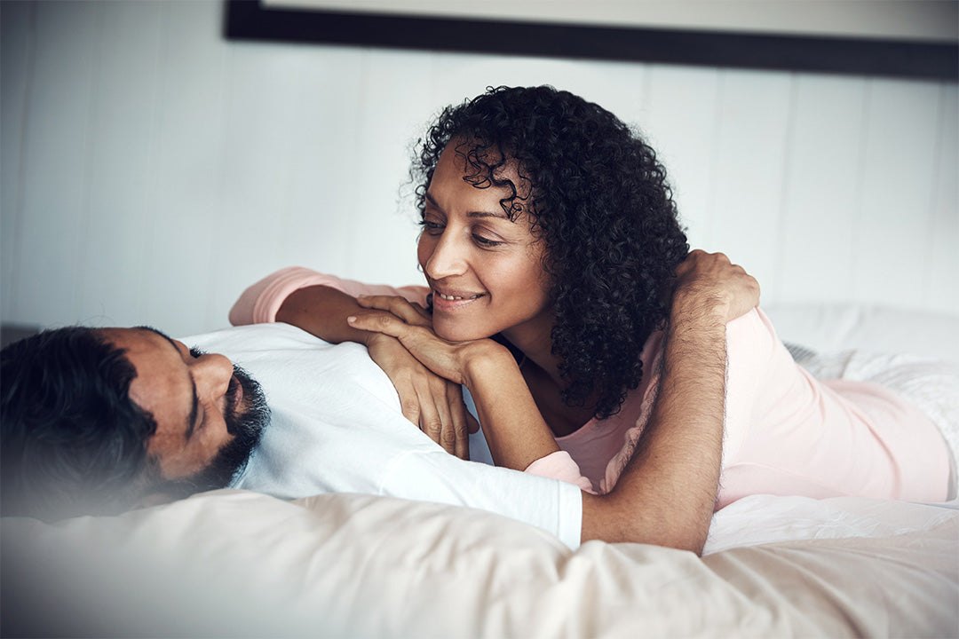 couple lying in bed talking about different sexual positions while discovering ways for sexual pleasure