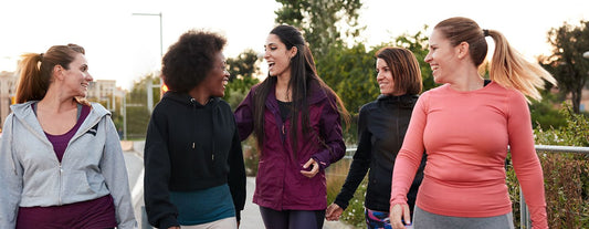 group of five perimenopause age women walking and smiling in athleisure attire