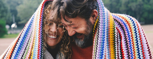 smiling couple wrapped in a blanket discussing menopause tips for husbands