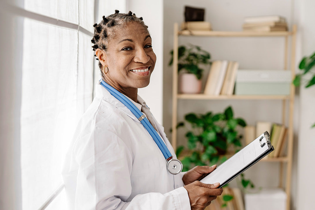 menopause doctor smiling with a clipboard in her hand