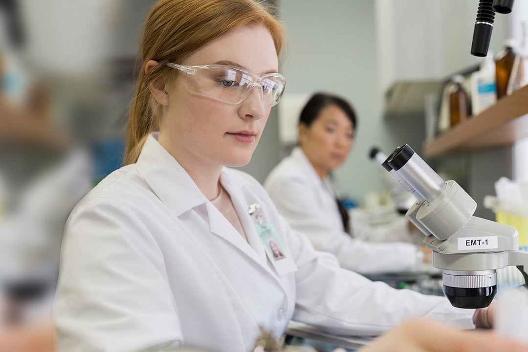 a woman in a lab testing a patient's blood for menopausal indicators such as FSH, LH & AMH levels