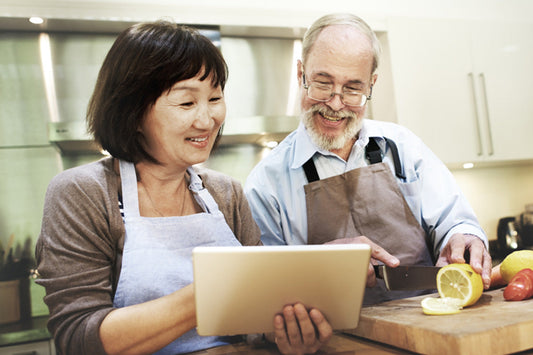 Older husband and wife cooking together using delicious winter foods for menopause