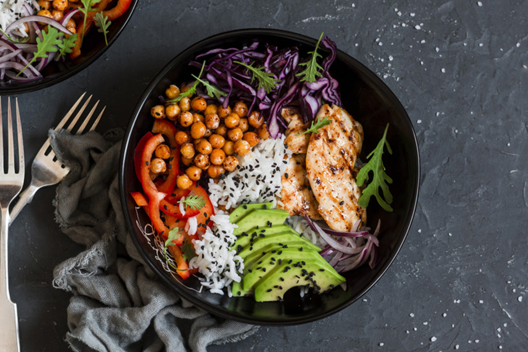 Two plates of a healthy balanced meal with protein, grains, and lots of vegetables