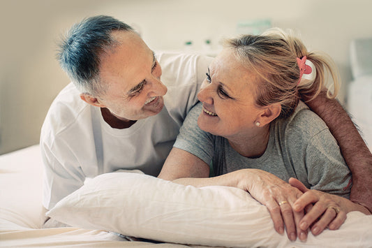 couple lying in bed talking about how to choose a lubricant for more comfortable sex during menopause