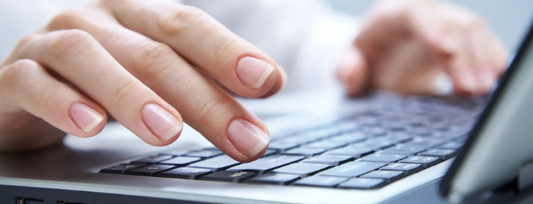 woman in menopause working on a computer after taking nail health supplements for healthy nails during menopause