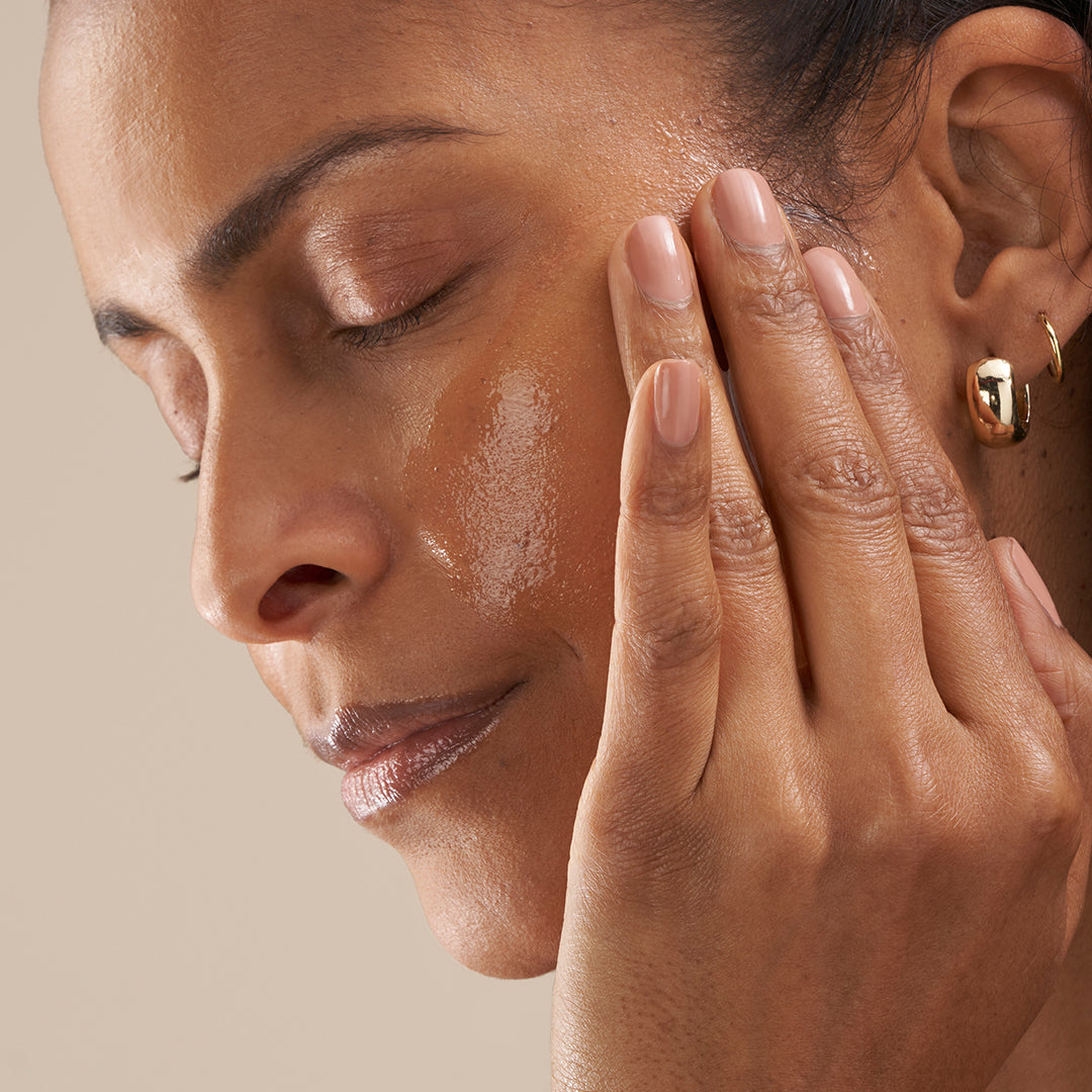 Woman going through menopause applying skin-firming collagen serum to her mature skin