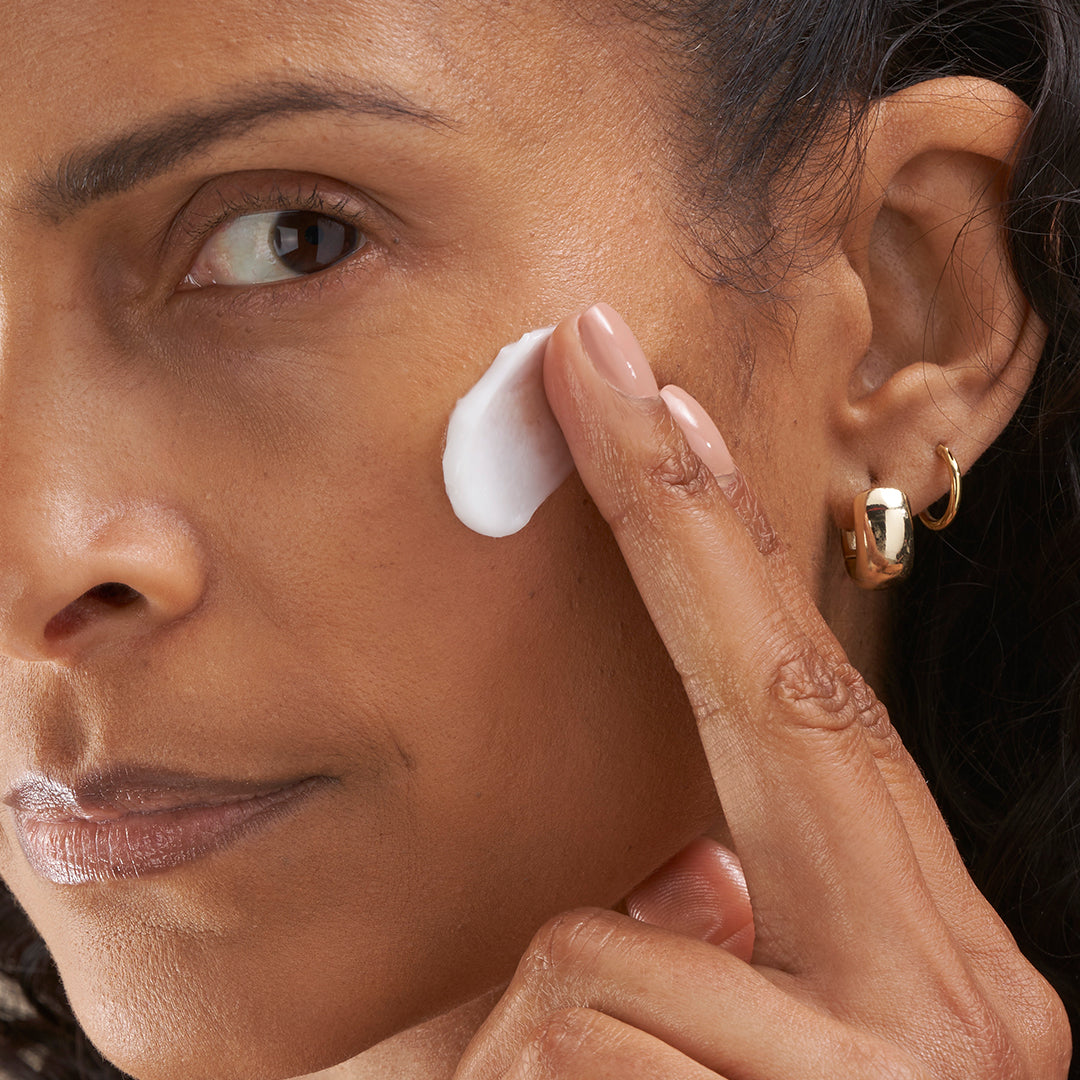 Woman in menopause applying the hydrating gel moisturizer to her aging skin