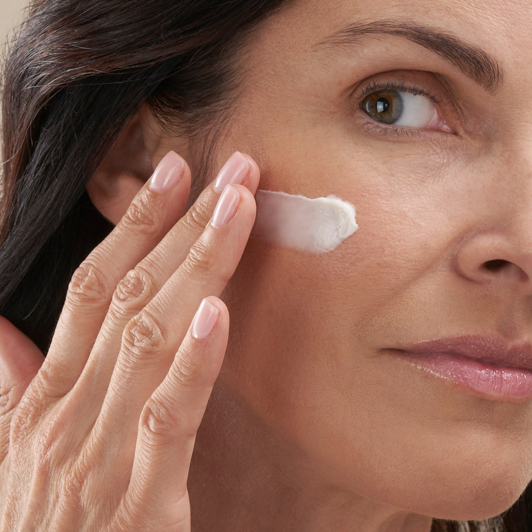 Woman in menopause applying the retinol facial night cream to her aging skin