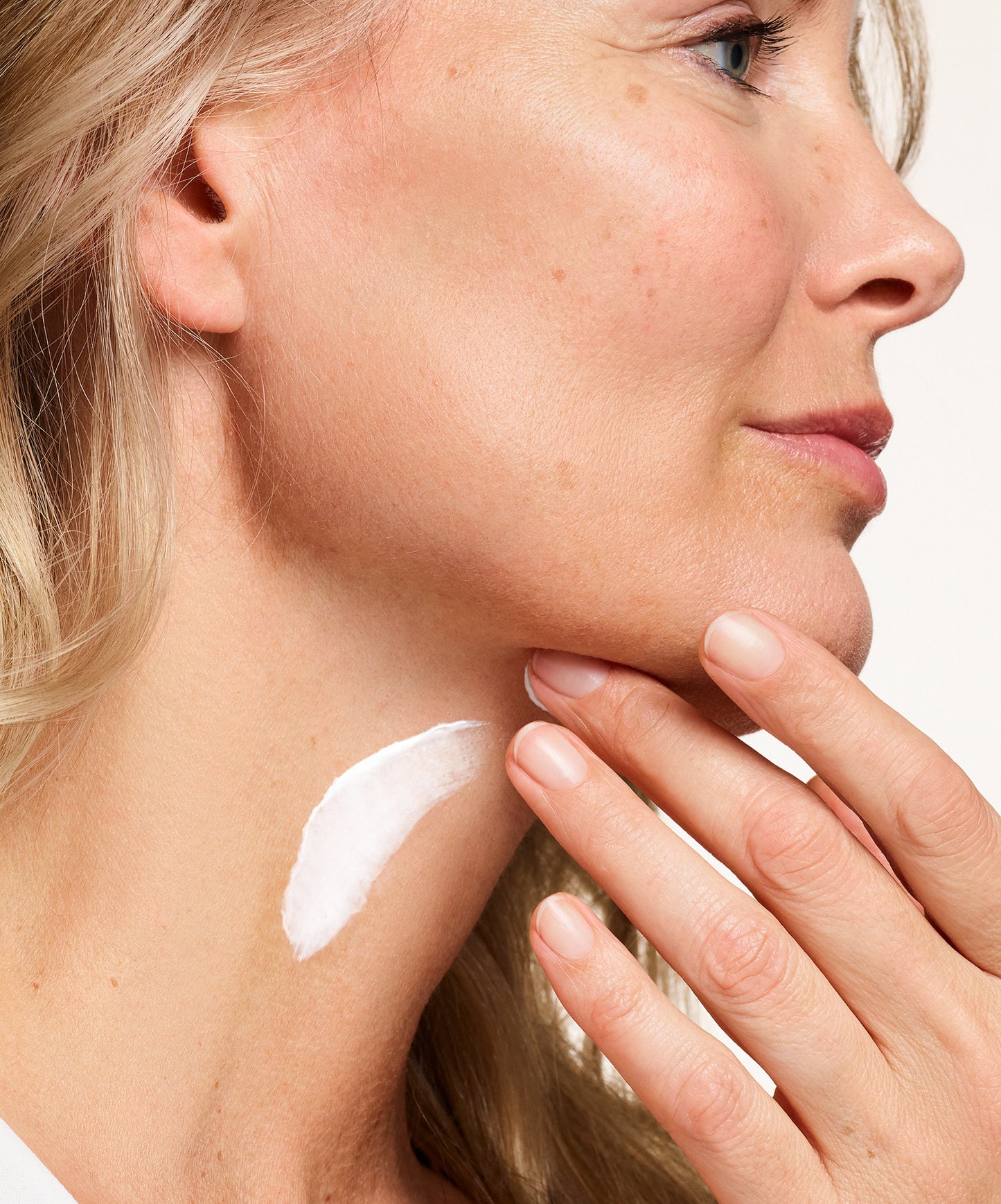 person putting NEOSTRATA Skin Active Firming Triple Firming Neck Cream on their neck